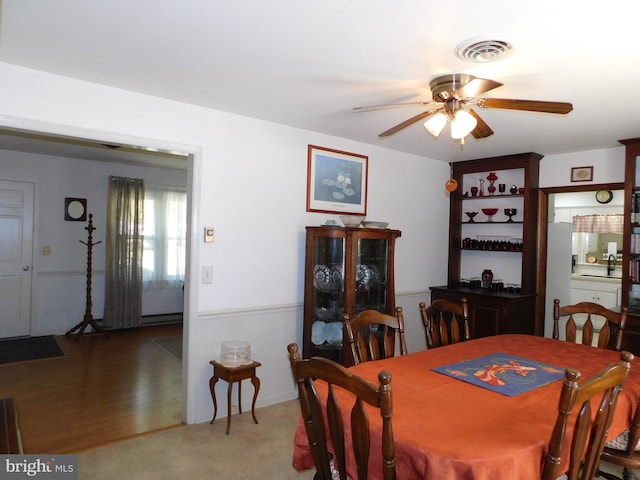 carpeted dining space featuring ceiling fan