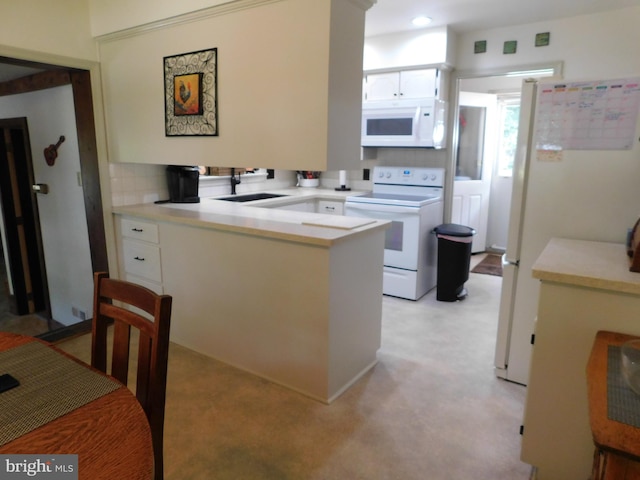 kitchen with sink, white appliances, backsplash, white cabinetry, and light carpet