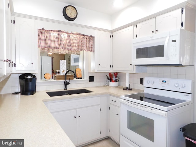 kitchen with white appliances, white cabinetry, sink, and tasteful backsplash