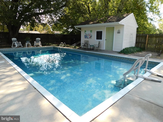 view of swimming pool with an outbuilding and a patio area