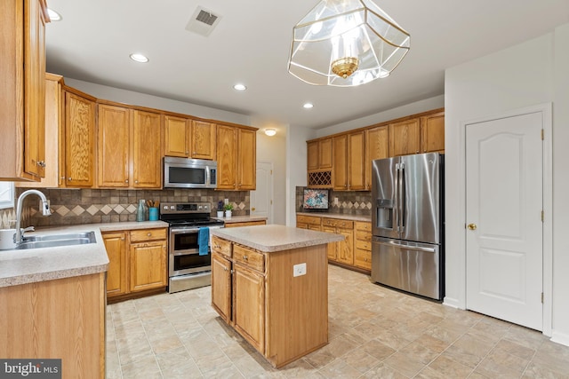 kitchen with pendant lighting, a center island, sink, an inviting chandelier, and stainless steel appliances