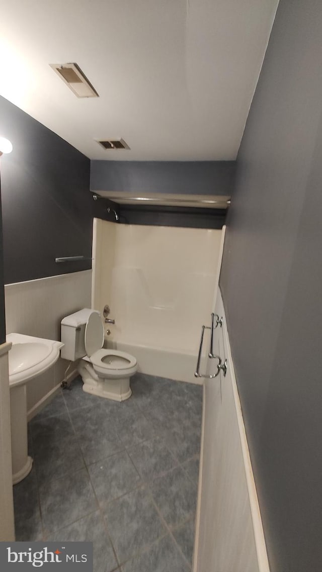 bathroom with toilet, tile patterned floors, and  shower combination