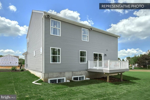 back of property featuring a lawn and a wooden deck