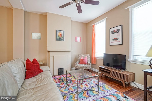 living room featuring ceiling fan and dark hardwood / wood-style floors