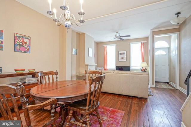 dining room with ceiling fan with notable chandelier and dark hardwood / wood-style floors