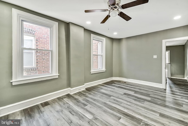 empty room with ceiling fan and hardwood / wood-style floors