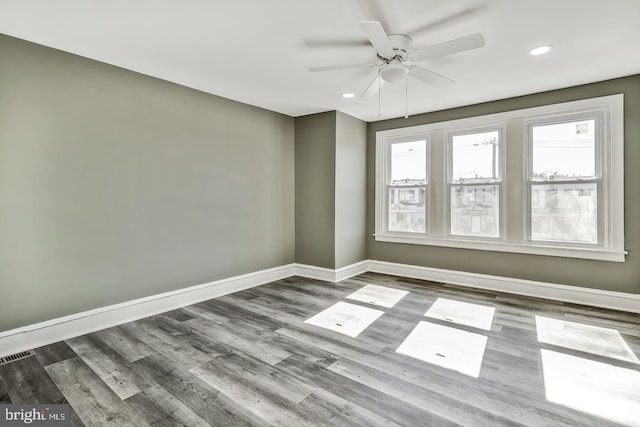 spare room featuring wood-type flooring and ceiling fan