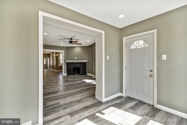 entryway featuring a fireplace, hardwood / wood-style flooring, and ceiling fan