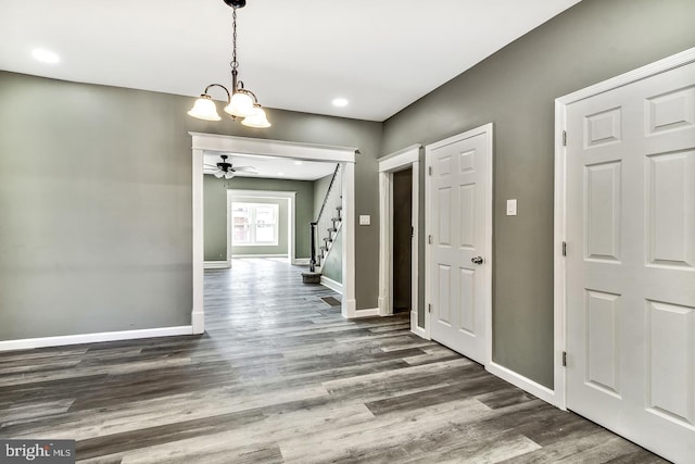 hallway with dark hardwood / wood-style floors and a chandelier