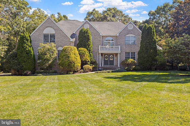 view of front of property with a balcony and a front yard