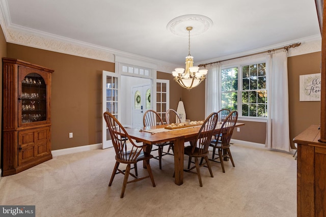 dining room with crown molding, an inviting chandelier, and light carpet