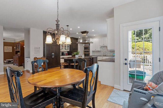 dining area with light hardwood / wood-style flooring and an inviting chandelier