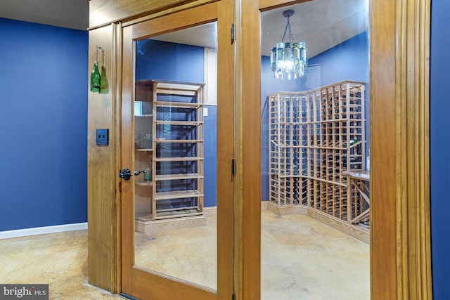 wine cellar with concrete floors and a chandelier