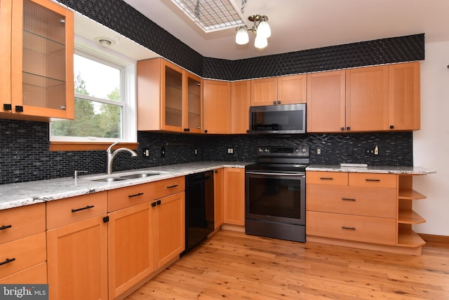 kitchen with appliances with stainless steel finishes, light wood-type flooring, sink, and tasteful backsplash