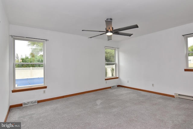 empty room with ceiling fan, light colored carpet, and a healthy amount of sunlight