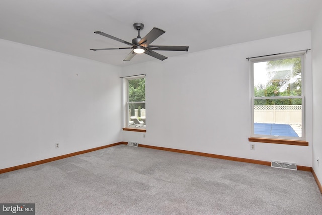 carpeted spare room featuring ceiling fan