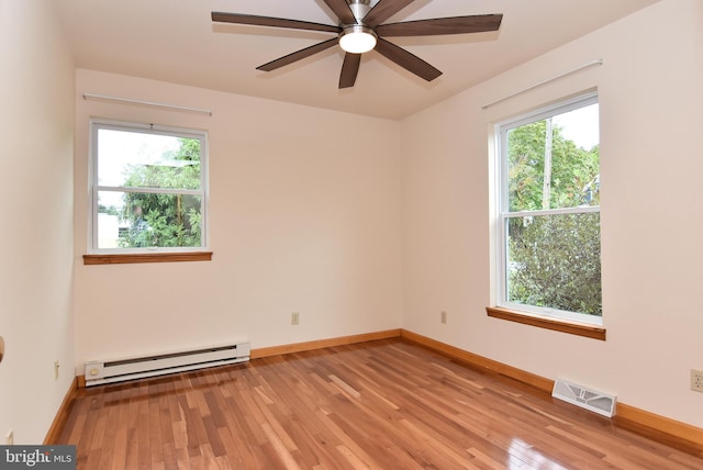 empty room with ceiling fan, a baseboard radiator, light wood-type flooring, and a wealth of natural light