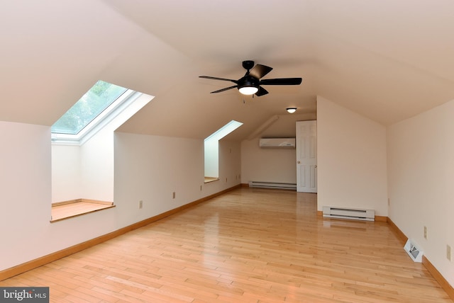 bonus room with light hardwood / wood-style floors, baseboard heating, ceiling fan, and a wall unit AC