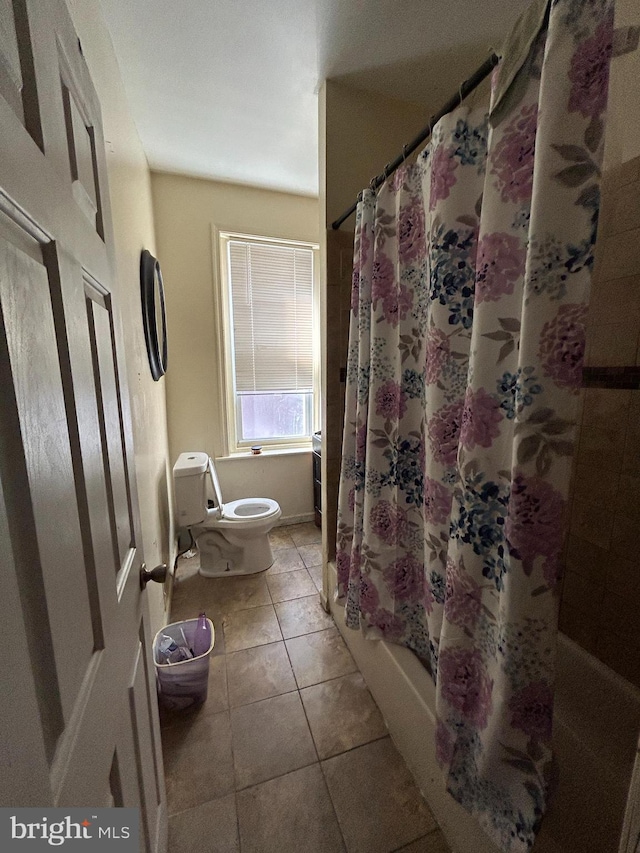 bathroom with tile patterned flooring, shower / bath combo, and toilet