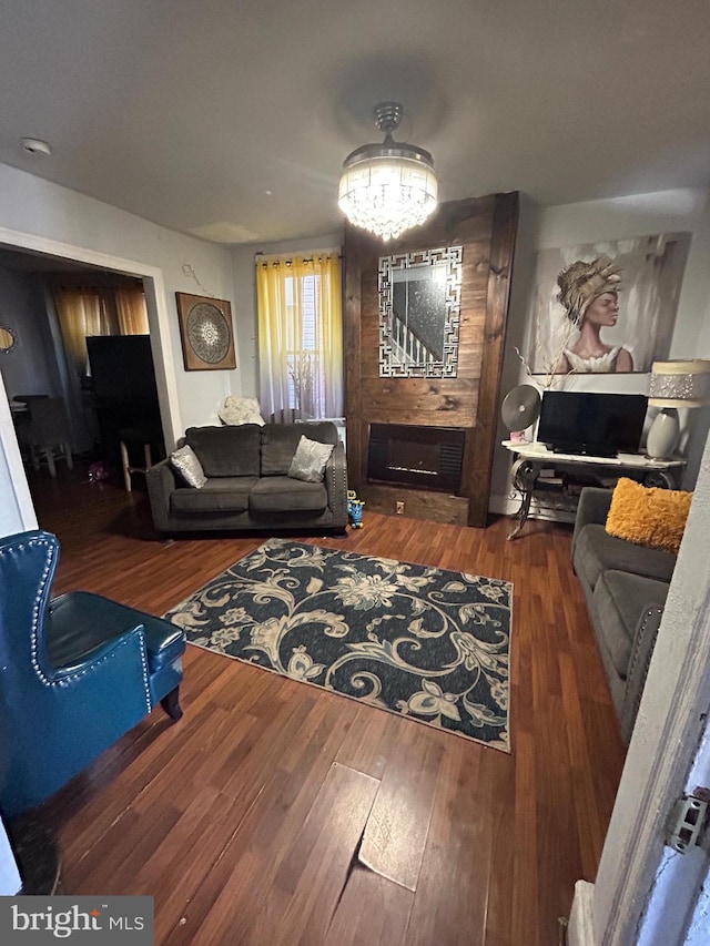 living room featuring hardwood / wood-style flooring, a fireplace, and a chandelier