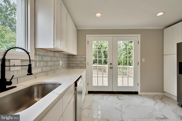 kitchen with french doors, white cabinets, sink, tasteful backsplash, and stainless steel appliances