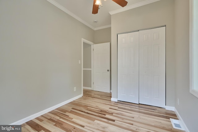 unfurnished bedroom featuring ceiling fan, a closet, crown molding, and light hardwood / wood-style flooring