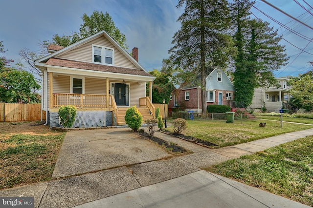 bungalow-style house featuring covered porch and a front yard