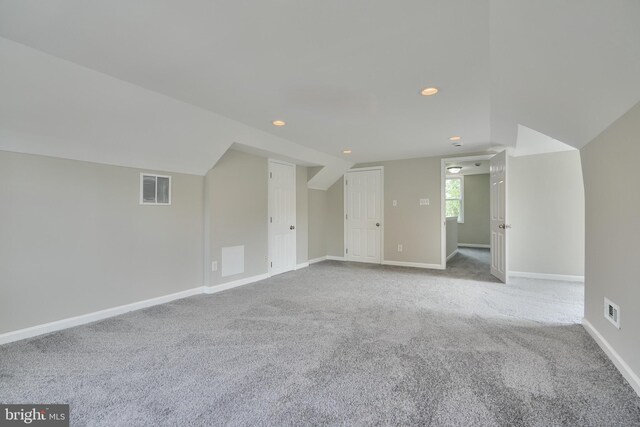 additional living space with light carpet and lofted ceiling