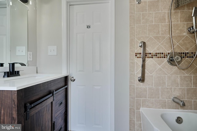 bathroom featuring vanity and tiled shower / bath