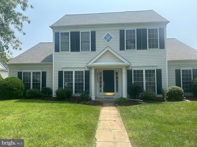 colonial house featuring a front yard