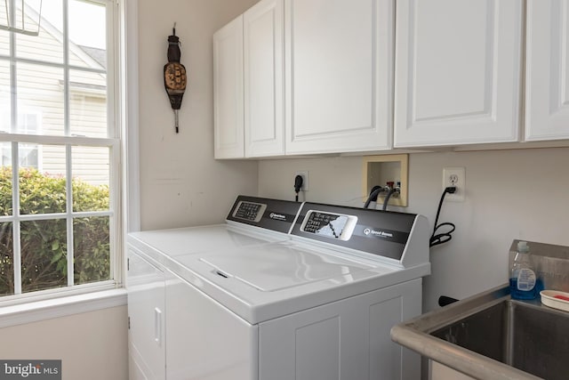 washroom featuring cabinets, plenty of natural light, and washer and clothes dryer