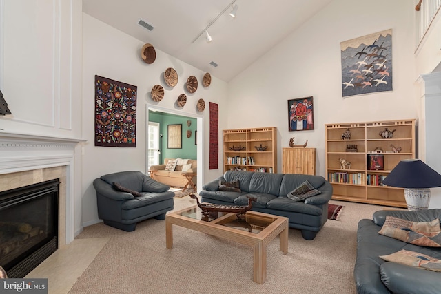 living room featuring light colored carpet, high vaulted ceiling, and rail lighting