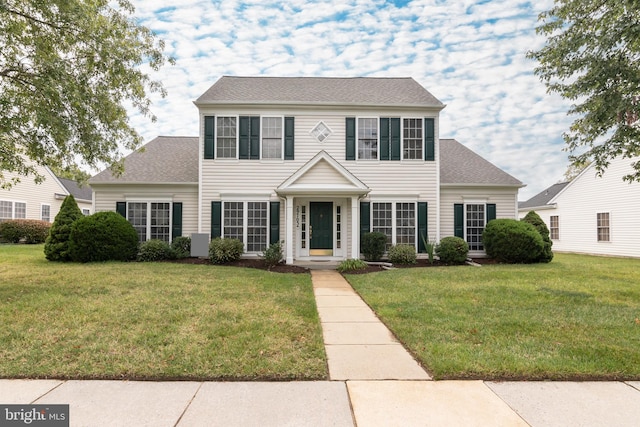 colonial-style house featuring a front yard