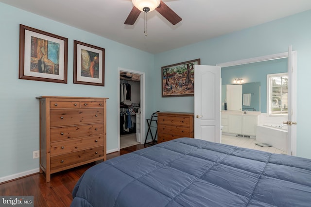 bedroom featuring connected bathroom, a closet, wood-type flooring, a spacious closet, and ceiling fan