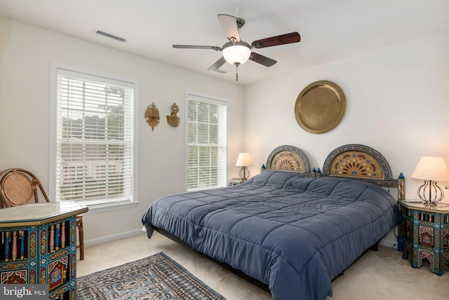 carpeted bedroom with multiple windows and ceiling fan