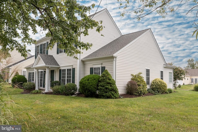 view of side of home with a yard