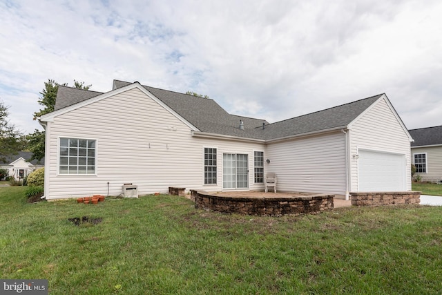 rear view of property with a patio, a garage, and a lawn