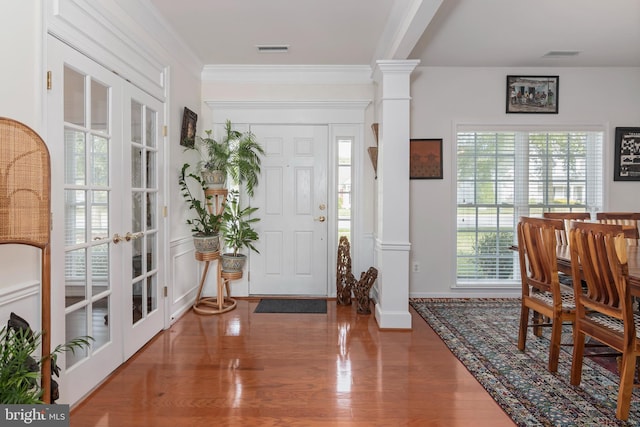 foyer entrance featuring french doors, hardwood / wood-style flooring, decorative columns, and a wealth of natural light