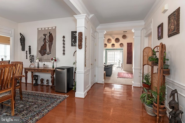 interior space featuring ornamental molding, decorative columns, and dark hardwood / wood-style floors