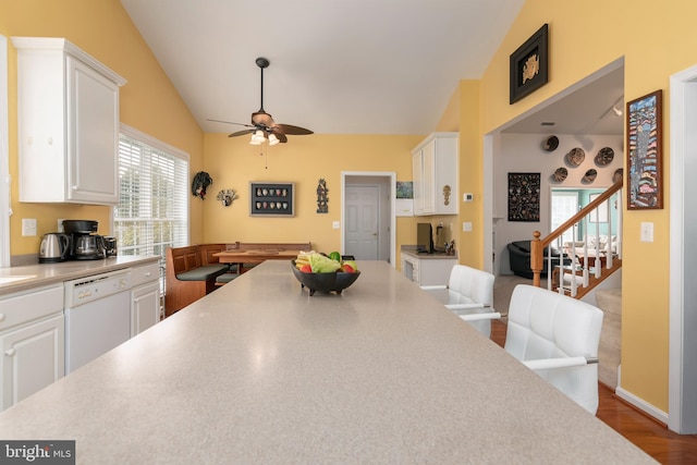 kitchen featuring vaulted ceiling, dishwasher, and white cabinets