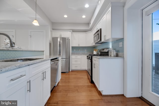 kitchen with white cabinets, light hardwood / wood-style floors, and appliances with stainless steel finishes