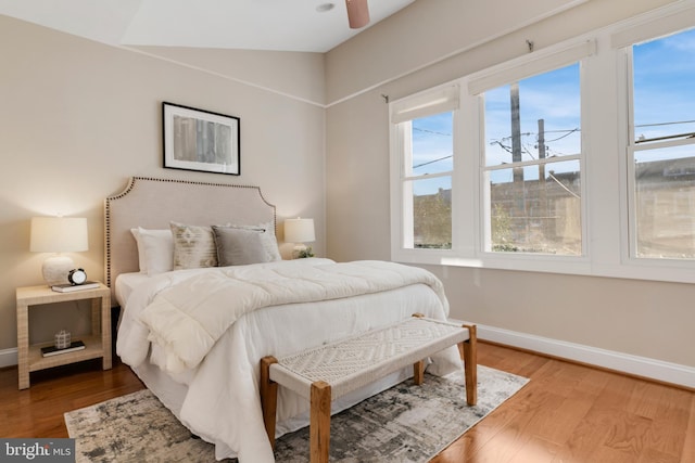 bedroom with wood-type flooring, lofted ceiling, multiple windows, and ceiling fan