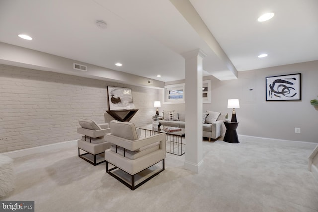 carpeted living room with brick wall