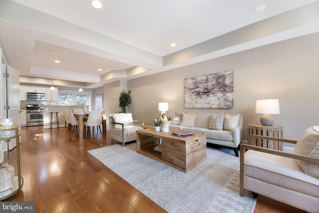 living room featuring a tray ceiling and hardwood / wood-style floors