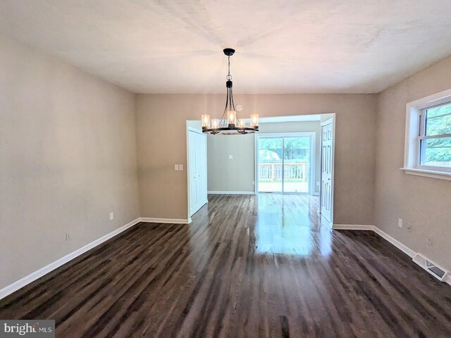 interior space featuring dark hardwood / wood-style floors and an inviting chandelier