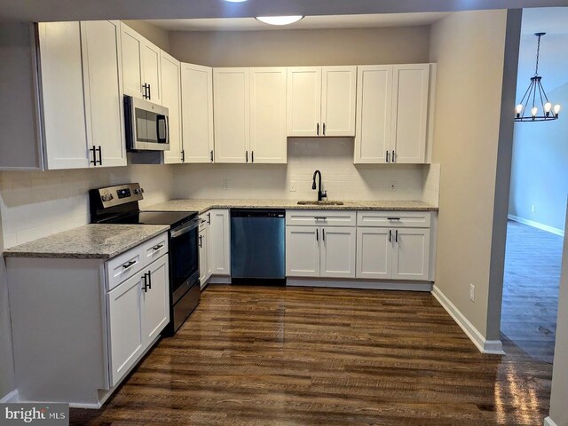 kitchen featuring a chandelier, sink, appliances with stainless steel finishes, and white cabinets