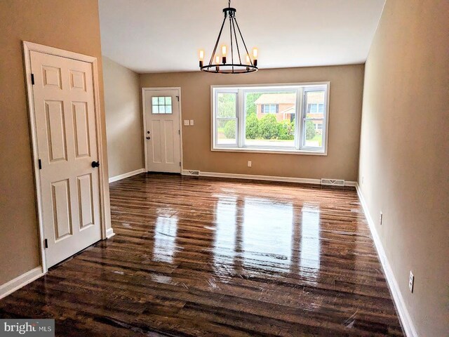 interior space featuring dark hardwood / wood-style flooring and an inviting chandelier