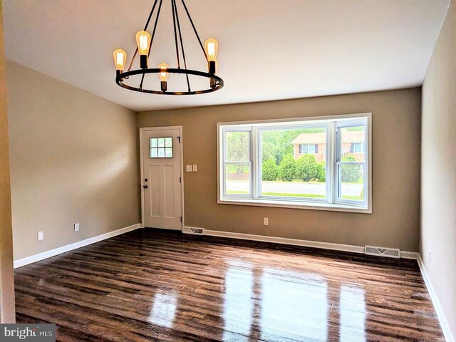 interior space featuring dark wood-type flooring and a chandelier