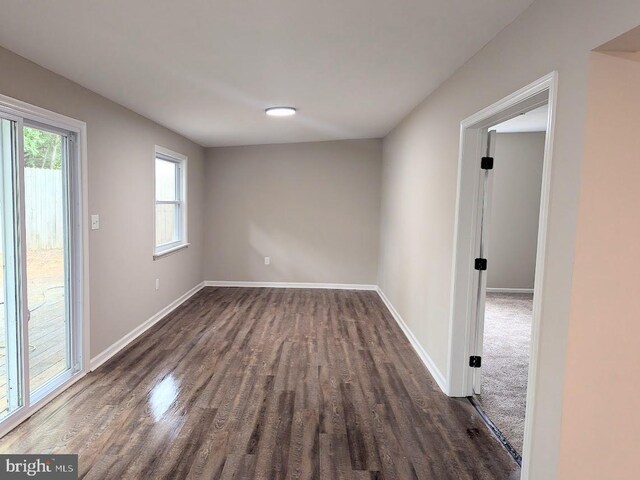 unfurnished room with dark wood-type flooring