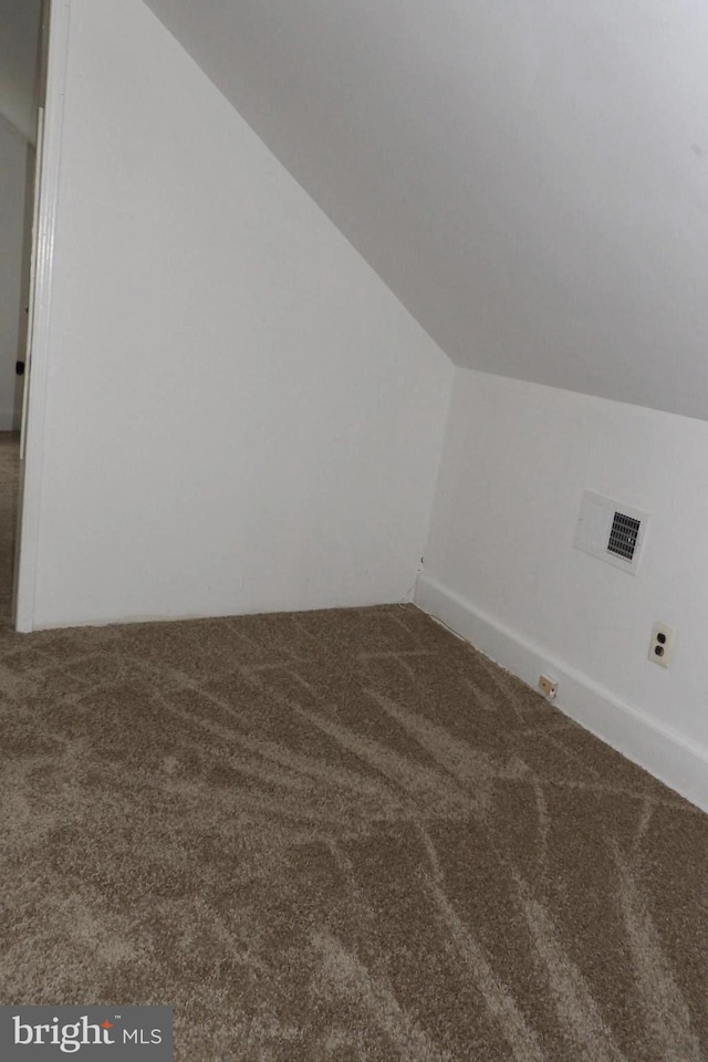 bonus room with carpet flooring and vaulted ceiling